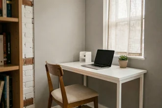 Coin bureau compact aménagé dans un petit appartement avec bureau mural blanc, chaise en bois et ordinateur portable