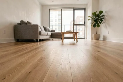 Salon moderne avec revêtement de sol en vinyle imitation chêne clair et canapé gris minimaliste